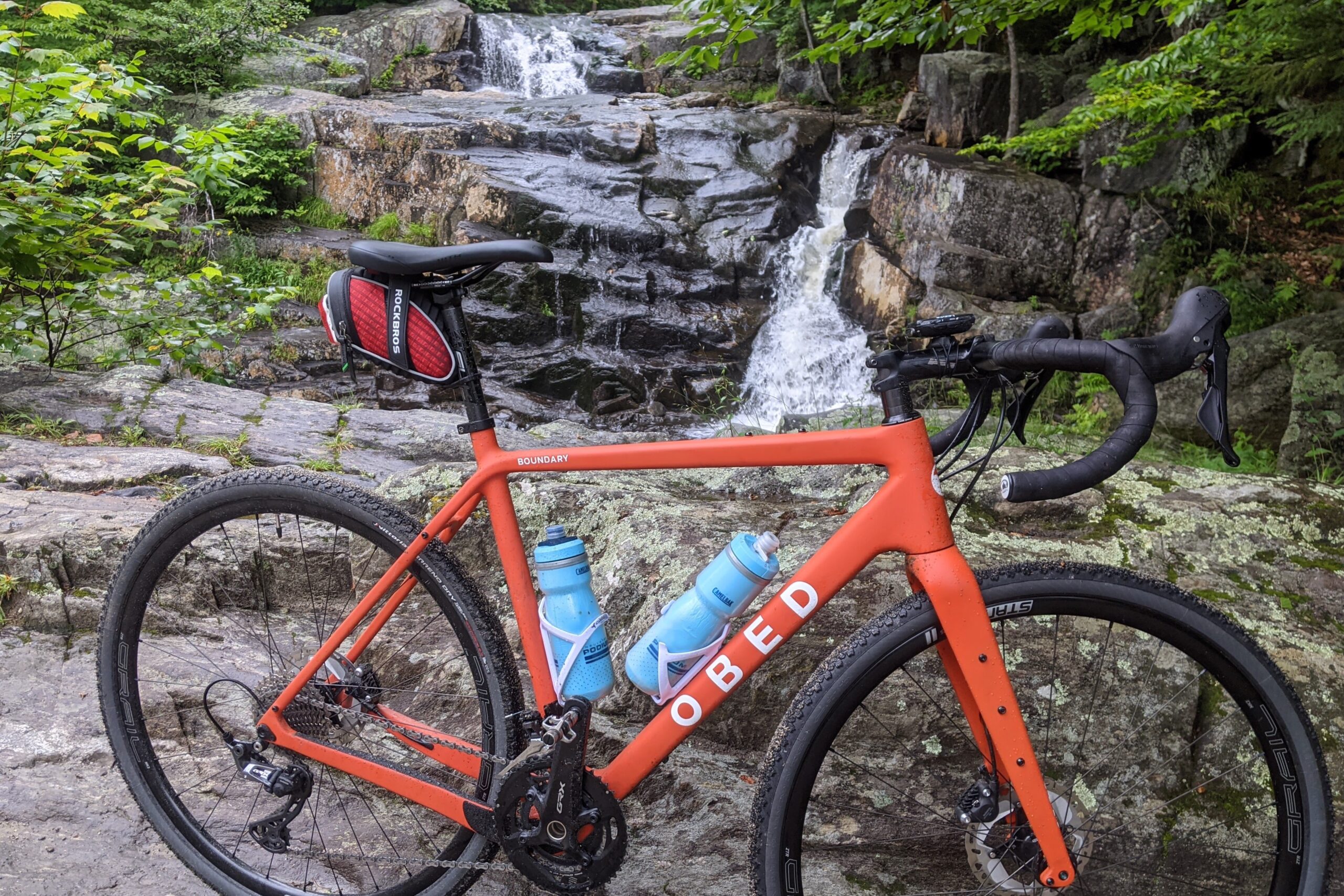 Gravel bike in front of a small waterfall